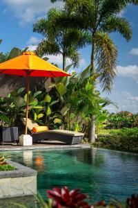 an orange umbrella next to a swimming pool at Sierra Vista 2 Ubud in Ubud