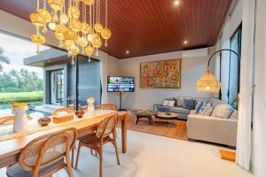 a dining room and living room with a table and chairs at Sierra Vista 2 Ubud in Ubud