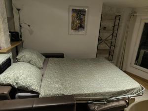 a bed in a room with a chair and a window at Le Nid plein centre in Salon-de-Provence