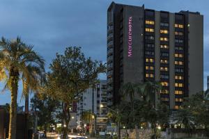 a tall building with a pink sign on it at Mercure Joinville Prinz in Joinville