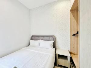 a small bedroom with a bed and a table at Iconic Regency Penang in Bayan Lepas