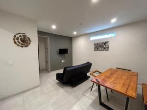 a living room with a black chair and a table at Departamentos frente a Chedraui in Tuxtla Gutiérrez