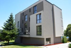 ein modernes Gebäude mit einem Baum davor in der Unterkunft Boutique Home Magnolia in Goldstrand