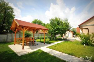 a wooden pavilion with a picnic table in a yard at Apartments Svetlica in Bački Petrovac