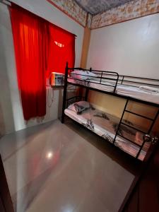 a room with two bunk beds and a red curtain at DC Travellers Inn in Malolos +8 photos