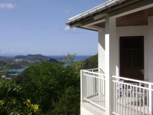 uma casa branca com uma varanda com vista em Abri Gens Libres em Le Marin