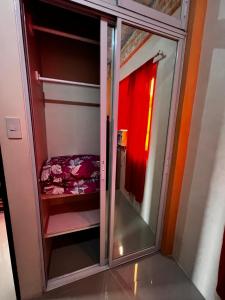 a glass closet with a bed in a room at DC Travellers Inn in Malolos