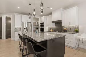 eine Küche mit weißen Schränken und eine große Insel mit Barhockern in der Unterkunft Sundance Den home in Harrisburg Junction