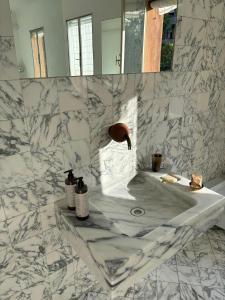 a white marble bathroom with a sink and a mirror at Arazzo Apartments in Modena