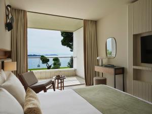 a hotel room with a bed and a view of the water at Kontokali Bay Resort & Spa in Kontokali