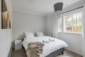 una camera da letto bianca con un letto grande e una finestra di Villa Borealis Levi a Levi