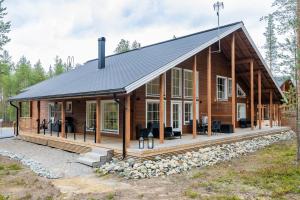 una grande casa in legno con tetto nero di Villa Borealis Levi a Levi