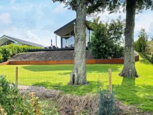 a house with two trees in a yard at Modern Beach House - By Traum Ferienwohnungen in Haslevgårde