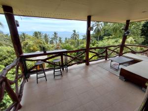 a balcony of a house with a table and chairs at House 2 Bedroom with Seaviews near Haad Rin in Koh Phangan