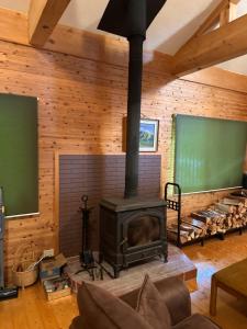 Una sala de estar con chimenea y un pizarrón verde. en 閼宗屋 Asoya, en Takamori