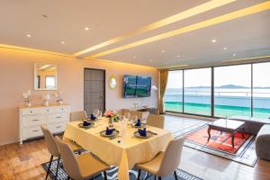 Un comedor con mesa y sillas y el océano. en Pattaya Sea View Apartment, en Pattaya South