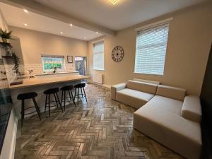 a living room with a couch and a kitchen at Modern 3 Bedroom house, short walk to train station and town centre, close to Manchester Airport and PLouise in Stockport