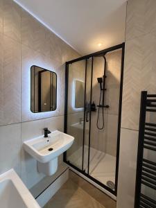 a bathroom with a sink and a shower at Modern 3 Bedroom house, short walk to train station and town centre, close to Manchester Airport and PLouise in Stockport