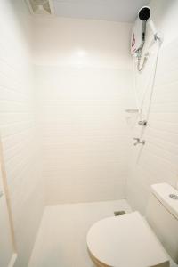 een witte badkamer met toilet en douche bij MGM tourist Inn in Tagbilaran-stad