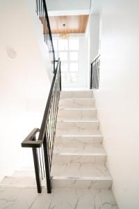 een trap met witte muren en zwarte relingen bij MGM tourist Inn in Tagbilaran-stad