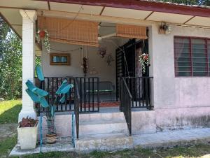 a porch of a house with a black fence at Homestay MMr in Temerloh