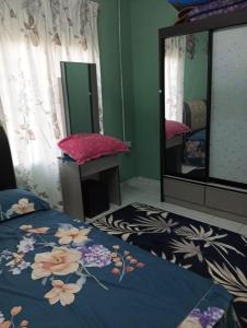 a bedroom with a bed and a mirror at Homestay MMr in Temerloh