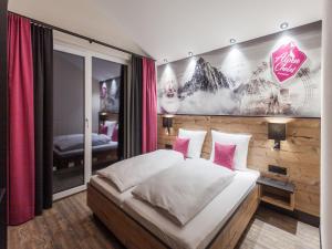 a bedroom with a bed with pink pillows at Chalet Montafon in Gaschurn with Sauna in Gaschurn +53 photos