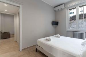 a white bedroom with a bed and a window at MI Michetti 20 in Milan