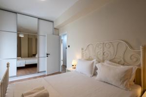 a bedroom with a large white bed with white pillows at Central Luxury Penthouse in Kalamata