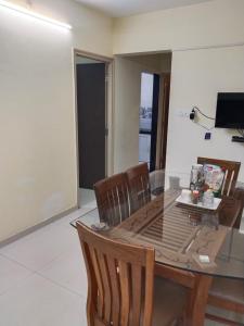 a dining room with a glass table and chairs at Shiv-Om in Jāmb