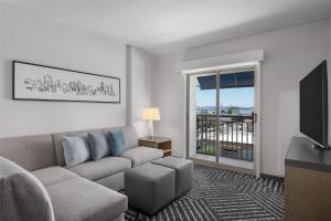 a living room with a couch and a flat screen tv at Hyatt House Emeryville in Emeryville