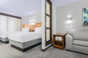 Un dormitorio con una cama, una silla y un espejo. en Hyatt Place Fort Worth/Hurst, en Hurst
