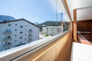 a room with a large window with a view at Latschüel by Arosa Vacations, Familienwohnung im Zentrum mit Privatparkplatz in Arosa