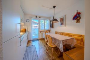 a kitchen with a table with chairs and a refrigerator at Latschüel by Arosa Vacations, Familienwohnung im Zentrum mit Privatparkplatz in Arosa