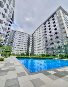 a large apartment building with a swimming pool at MG Place -2 BR condo unit at SMDC Charm Residences, Cainta, Rizal, 1900 in Cainta +22 photos
