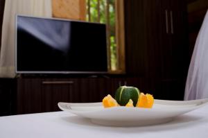 a plate of fruit on a table with a television at Tayrona Paradise in El Zaino