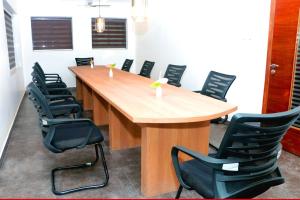a conference room with a large wooden table and chairs at Keerthy Palace Cherthala in Turavūr