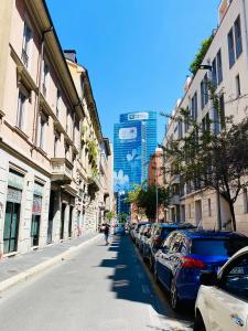 eine Straße mit einer Reihe von Autos, die neben Gebäuden geparkt sind in der Unterkunft Isola View Bosco Verticale in Mailand