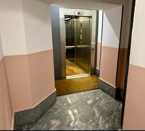 ミラノにあるLa Casa Dei Viaggiatoriのガラス戸建ての建物内のエレベーター