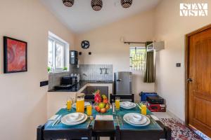 a kitchen with a table with a bowl of fruit on it at StayVista at Rustling Pine with Bonfire, BBQ & Lawn in Ooty