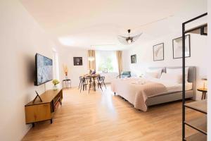 a bedroom with a large bed and a dining room at C&S Living I Terrasse I Küche I Parkplatz in Tauberbischofsheim