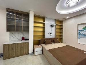 1 dormitorio con 1 cama y cocina con estanterías en Hotel 21 Bắc Ninh, en Kon Rung (1)