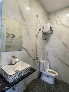 Un baño con lavabo, inodoro y espejo. en Hotel 21 Bắc Ninh, en Kon Rung (1)
