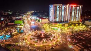 a city at night with a clock in the middle at Sophia Center - Serviced Apartment - Duke Hospitality in Rach Gia