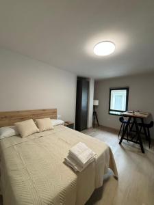 ルーゴにあるApartamentos muralla de Lugoのタオルが敷かれた大きなベッドのある寝室