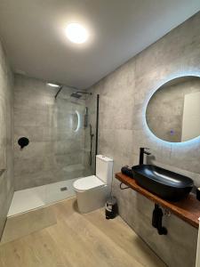 ルーゴにあるApartamentos muralla de Lugoの洗面台、トイレ、鏡のあるバスルーム