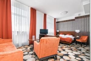 a hotel room with a bed and a tv and chairs at Kmicic in Kraśnik