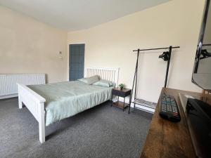 a bedroom with a bed and a television in it at Budget Spacious 3 bed home in manchester in Manchester