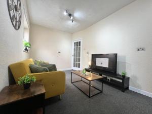 a living room with a couch and a tv at Budget Spacious 3 bed home in manchester in Manchester +19 photos
