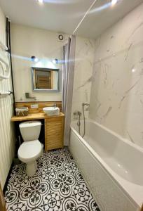 a bathroom with a toilet and a sink and a tub at New apartment in JYSK style in Cherkasy